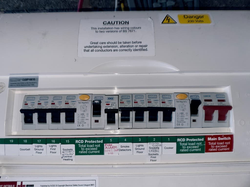Consumer unit with labelled circuits, including lighting, sockets, cooker and fire alarm