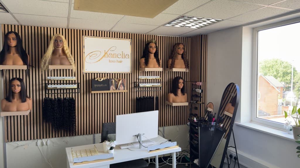 Slatted timber feature wall with display shelves, lighting and a salon sign
